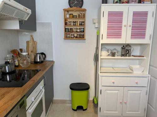 a small kitchen with white cabinets and a green trash can at CASITA, Costa Calma, 2 SZ, Glasfaser Wifi, gute Lage, Strandnähe in Costa Calma