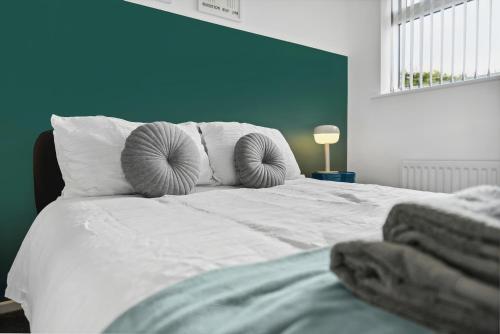 a large white bed with two pillows on it at Stylish Home From Home 3 bed house, sleeps 6, private parking, WiFi Leamington Spa in Leamington Spa