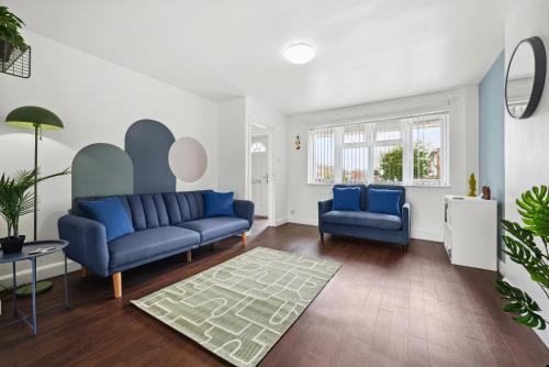 a living room with two blue couches and a rug at Stylish Home From Home 3 bed house, sleeps 6, private parking, WiFi Leamington Spa in Leamington Spa