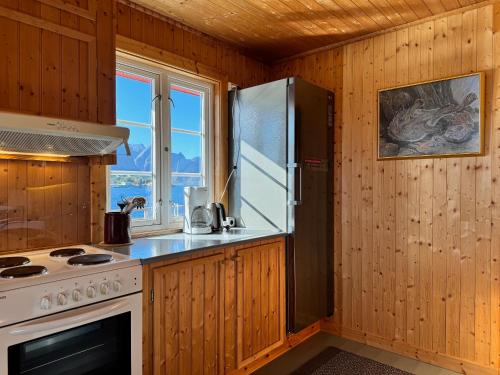 a kitchen with a refrigerator and a stove top oven at Toppøy Rorbuer in Reine