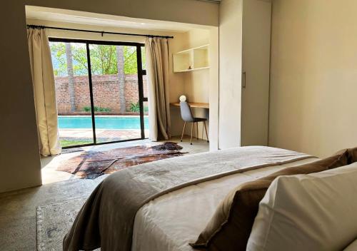 Un dormitorio con una cama y vistas a una piscina. en Molenhof, en Somerset East