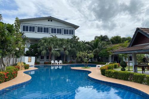 a swimming pool in front of a house at Baan Sanuan Resort in Ban Sawai Chik Noi