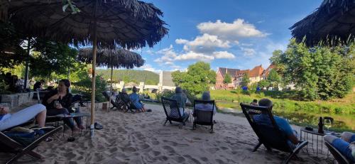 a group of people sitting in chairs under an umbrella at Ferienwohnung am Donauradweg in Tuttlingen