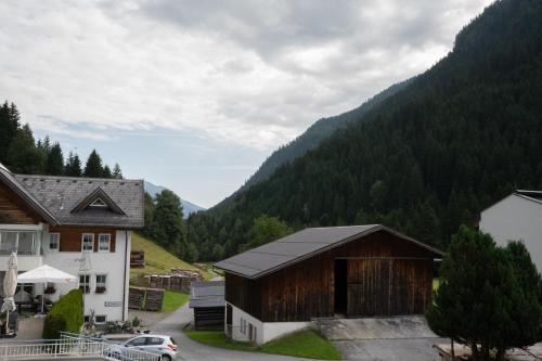 a village with a barn and a mountain at Haus Forellenhof in Ischgl
