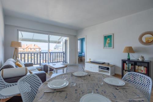 un salon avec une table et des chaises dans l'établissement Appartement Ornano - Welkeys, à Blonville-sur-Mer