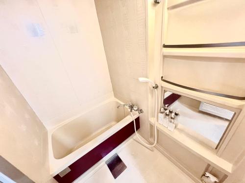 a small bathroom with a tub and a shower at 8min walk from Namba Station for 4 people gran704 in Osaka