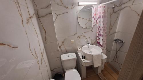 a white bathroom with a sink and a toilet at Amaya Pine Studio in Panayia