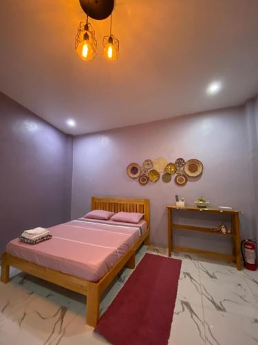 a bedroom with a bed and a table at Aliyah Transient House in Atimonan