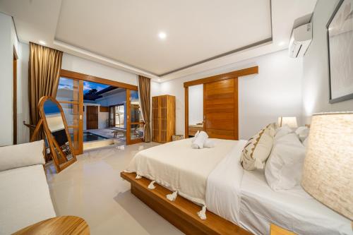 a bedroom with a white bed and a balcony at Special Offer! Elegant 2-Bedroom Villa with Large Pool in Canggu! in Canggu