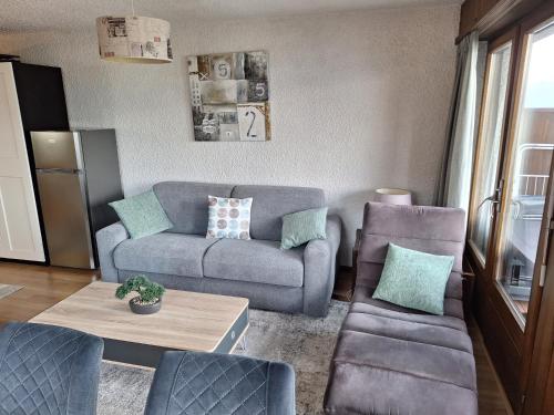 a living room with a couch and a table at Les Collons1800- Bel appart 2pièces-4 pers-piscine-sauna-parking int-Wifi gratuit in Vex