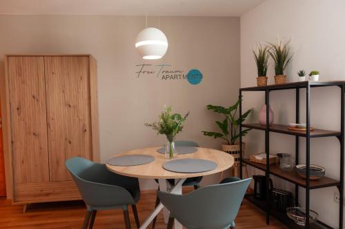 a table and chairs in a room with a pendant light at FreiTraum Apartments No3 City mit eigenem Garten in Bad Neustadt an der Saale