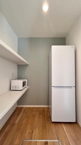 a kitchen with a white refrigerator and a microwave at HiL town yamanashi 12 MSDG in Kofu