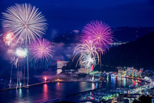 a firework display over a city at night at Chateraise Lodge Atami in Atami
