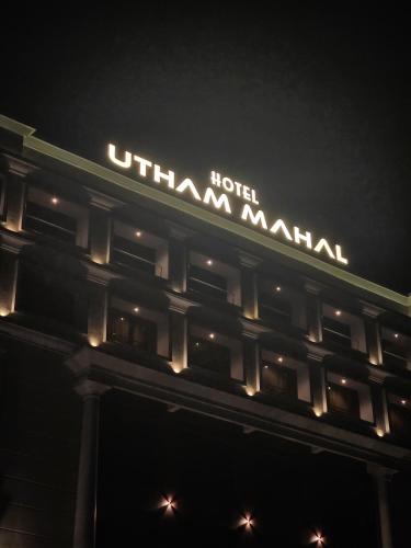 a hotel sign on top of a building at night at Utham Mahal in Anchal