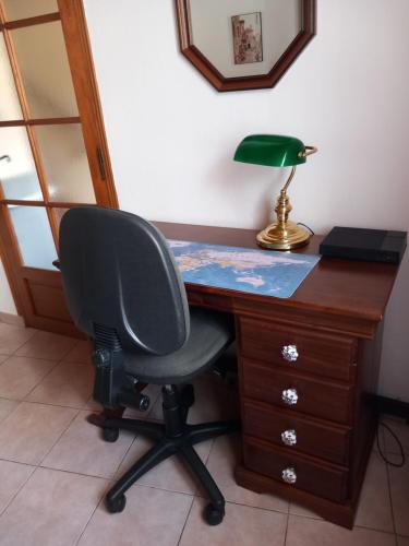 a desk with a chair and a lamp on it at Maison des trois ormeaux in Cier-de-Luchon