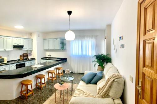 a living room with a couch and a kitchen at Your Holiday Home - El Tablado - Tenerife Sur in El Escobonal