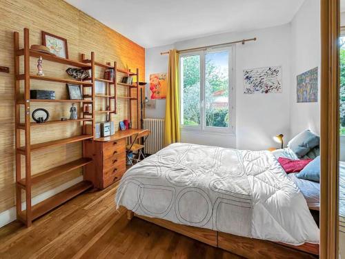 a bedroom with a bed and a desk and a window at Villa arborée aux Portes de Paris in Bobigny