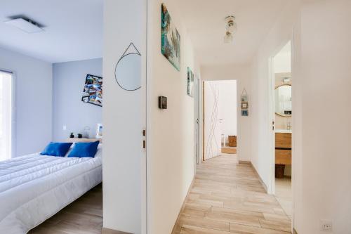 - une chambre blanche avec un lit et un couloir dans l'établissement Maison moderne avec jardin - 5min de la plage, à Erquy