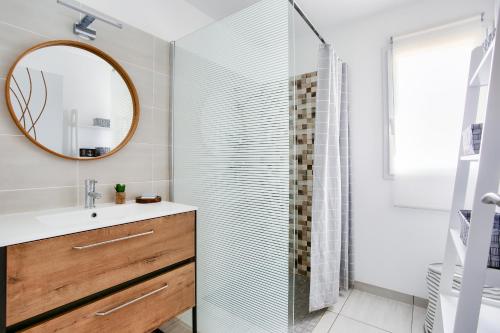 une salle de bain avec une douche avec un lavabo et un miroir dans l'établissement Maison moderne avec jardin - 5min de la plage, à Erquy