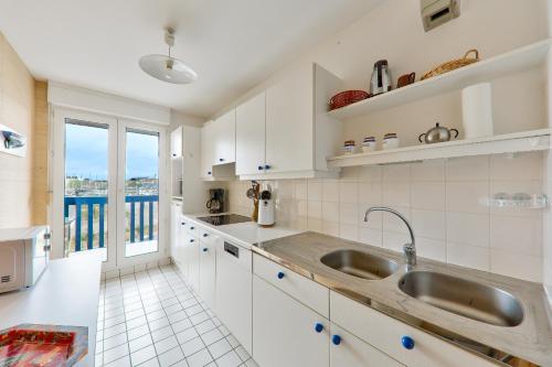 une cuisine avec un évier et une grande fenêtre dans l'établissement Port du Crouesty, appartement pour 4 avec piscine, à Arzon