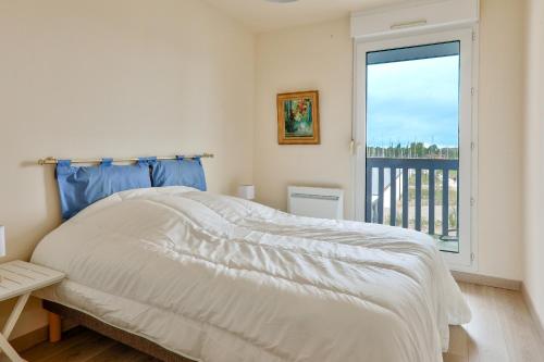 une chambre blanche avec un lit et une fenêtre dans l'établissement Port du Crouesty, appartement pour 4 avec piscine, à Arzon