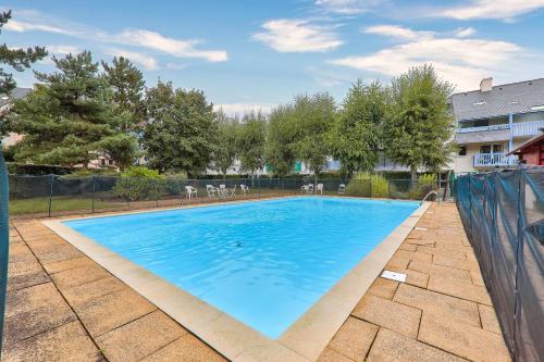 une grande piscine bleue dans une cour dans l'établissement Port du Crouesty, appartement pour 4 avec piscine, à Arzon