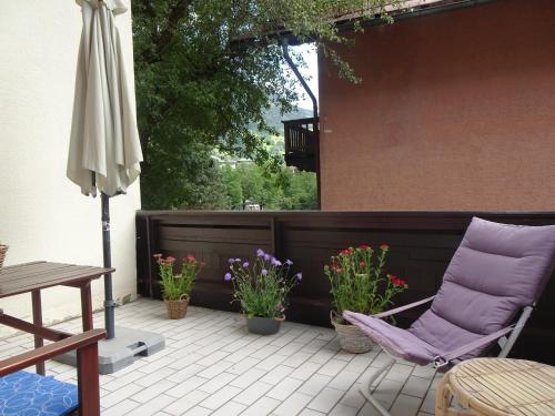 a patio with a purple chair and some plants at Schlossalm Appartement in Bad Hofgastein