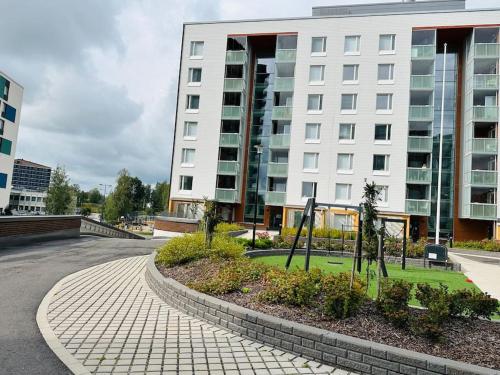 埃斯波Aurora Home Espoo Niittykumpu - New 1bedroom -apartment with balcony, close to metro, Aalto University, Metro Areena and Helsinki的大楼前的白色大建筑