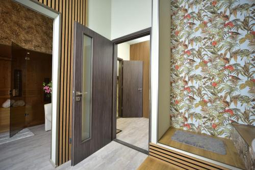 a hallway with a mirror and a wall with a floral wallpaper at TF Wellness in Prague