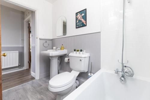 a bathroom with a toilet and a sink and a tub at Whole 3 Bedroom House - 2 Free Parking in St. Albans
