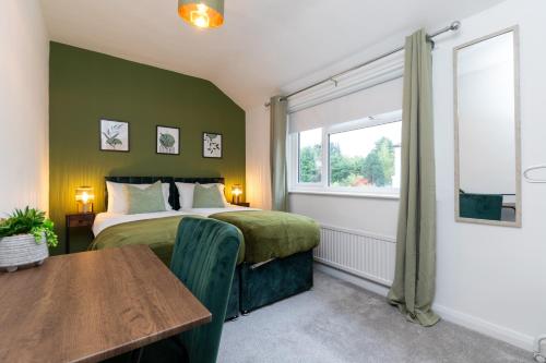 a bedroom with a bed and a table and a window at Whole 3 Bedroom House - 2 Free Parking in St. Albans