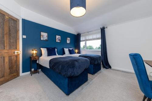 a blue bedroom with a bed and a window at Whole 3 Bedroom House - 2 Free Parking in St. Albans