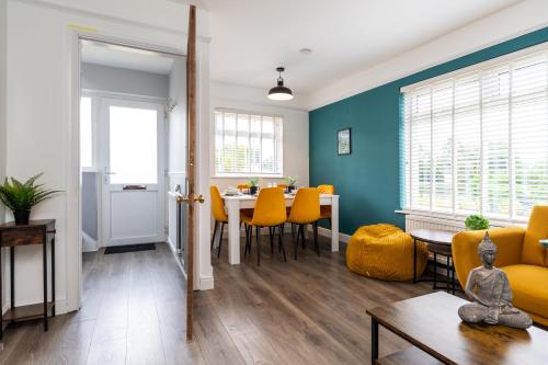 a living room with a table and yellow chairs at Whole 3 Bedroom House - 2 Free Parking in St. Albans