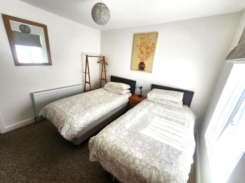 a bedroom with two beds and a window at Bassett Flat with 2 Bedrooms and Superfast Wi-Fi in Sittingbourne
