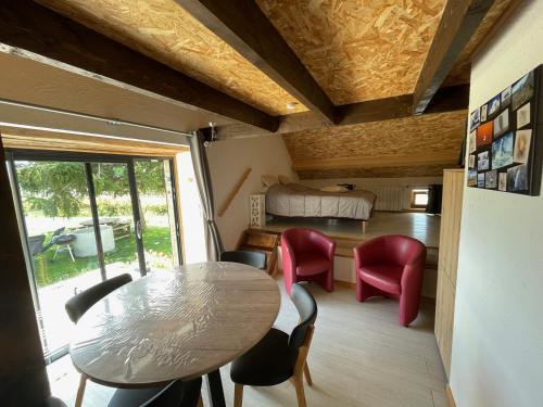 une pièce avec une table, des chaises et un lit dans l'établissement L’oustal, à Nasbinals