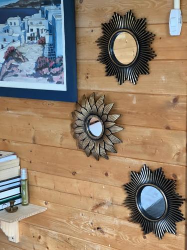 a wall with two mirrors and a sunflower on it at The Cabin in Bradford on Avon