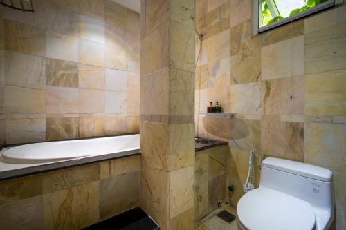 a bathroom with a toilet and a bath tub at Benzen Boutique Villa Private Pool By Da Nang Beach 8Pax in Da Nang