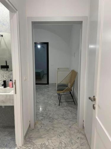 a hallway with a mirror and a chair in a room at Villa Jedidi in Hammamet Sud