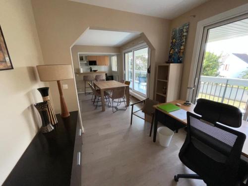 un salon avec un bureau et une table avec des chaises dans l'établissement Appartement St Germain, à Maisons-Laffitte