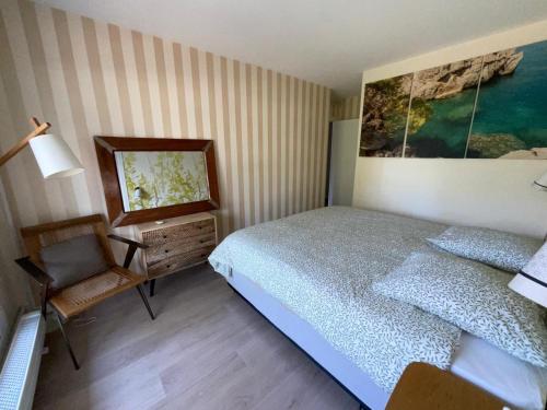 une chambre avec un lit, un bureau et un tableau dans l'établissement Appartement St Germain, à Maisons-Laffitte