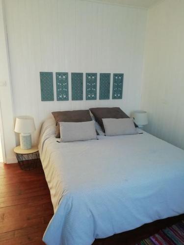 Cette chambre comprend un grand lit et 2 lampes. dans l'établissement MAISON T4 style ARCACHONNAISE, à Gujan-Mestras