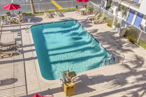 an overhead view of a swimming pool with chairs and umbrellas at Motel 6-Phoenix, AZ - West in Phoenix
