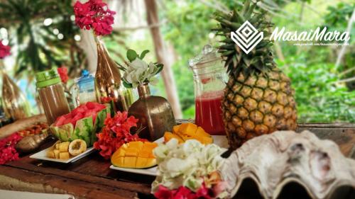 una mesa cubierta con platos de fruta y piña en Masai Mara Zanzibar - Boutique Hotel, en Jambiani