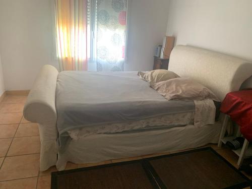 un lit blanc dans une chambre avec une fenêtre dans l'établissement Loft cosy, à Carcassonne