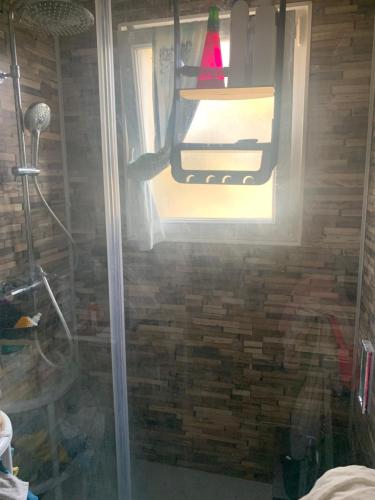 d'une douche avec une porte en verre et une fenêtre. dans l'établissement Loft cosy, à Carcassonne