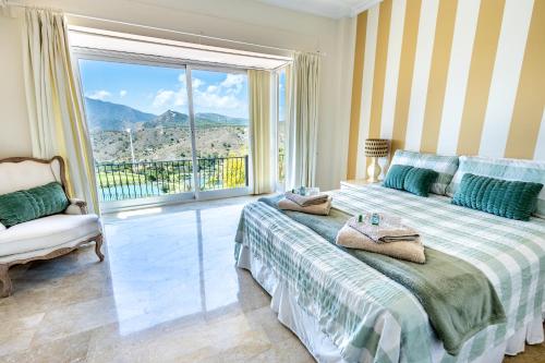 阿尔豪林格朗德Stunning Golf Villa with Pool and Stunning Views的一间卧室，里面有一张床和一扇大窗户。