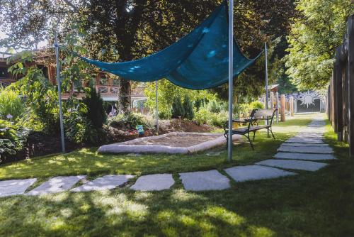 a blue hammock in a garden with a bench at Hotel DIE SONNE in Saalbach Hinterglemm