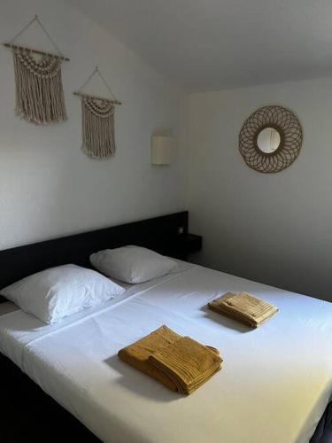 un lit blanc avec deux serviettes dessus dans l'établissement Élégant duplex sur Arles, à Pont de Chamet