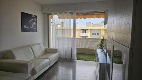 un salon avec un canapé et une grande fenêtre dans l'établissement Beau studio avec parking, à Cagnes-sur-Mer