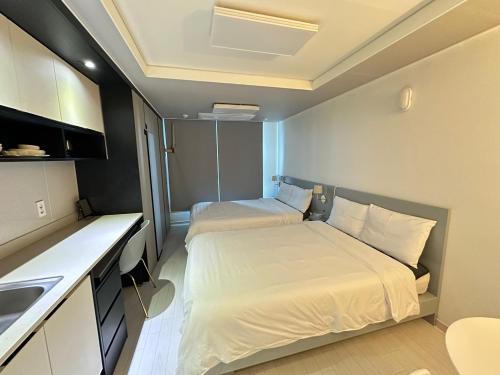 a small room with two beds and a kitchen at Tempus urban stay hotel in Daegu